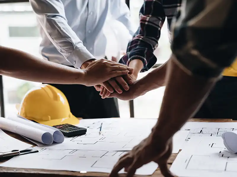 hands all-in teamwork at a construction site